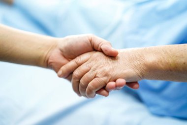 Holding dokunmadan eller Asya kıdemli veya yaşlı yaşlı kadın kadın hasta ile sevgi, bakım, yardım, teşvik ve hastane koğuşunda Hemşirelik, empati: sağlıklı güçlü tıp kavramı