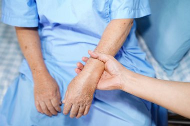 Holding dokunmadan eller Asya kıdemli veya yaşlı yaşlı kadın kadın hasta ile sevgi, bakım, yardım, teşvik ve hastane koğuşunda Hemşirelik, empati: sağlıklı güçlü tıp kavramı