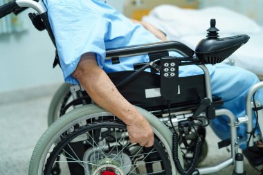 Asya kıdemli veya yaşlı yaşlı kadın kadın hasta hastane koğuşunda hemşirelik, uzaktan kumanda ile elektrikli tekerlekli sandalye üzerinde: sağlıklı güçlü tıp kavramı