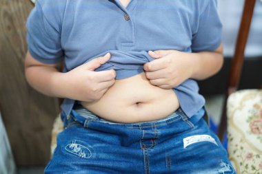 Şişman Asyalı çocuklar. Küçük çocuk şişman göbek gösteriyor..