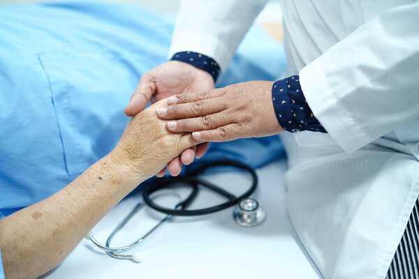 Holding Touching hands Asian senior or elderly old lady woman patient with love, care, helping, encourage and empathy at nursing hospital ward : healthy strong medical concept