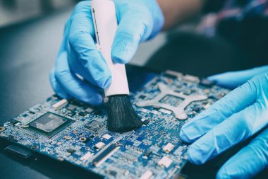 Asyalı teknisyen tamir ve temizlik kirli toz mikro devre ana bilgisayar elektronik teknolojisi fırça ile: donanım, cep telefonu, akıllı telefon, yükseltme konsepti