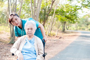 Doktor yardım ve bakım Asya yaşlı yaşlı yaşlı kadın hasta hemşirelik hastanesi koğuşunda parkta tekerlekli sandalyede oturan: sağlıklı güçlü tıbbi kavram 