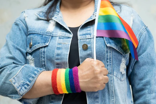 レズビアン バイセクシャル トランスジェンダー 人権の6月の社会では 青いジーンジャケットやデニムシャツを着て虹色の旗を持っているアジアの女性 Lgbtの誇りの月のシンボルは毎年祝う — ストック写真