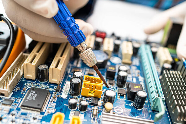 техник восстанавливает внутри жесткого диска паяльник. Интегрированный круг. концепция данных, оборудования, техников и технологий.