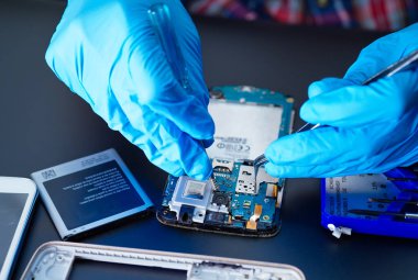 Teknisyen, sabit diskin içinde lehim yaparak tamir ediyor. Bütünleşik devre. Veri, donanım, teknisyen ve teknoloji kavramı.