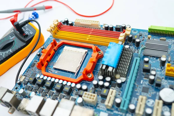 Multimeter with main board, maintenance, repairing and checking computer hardware concept.