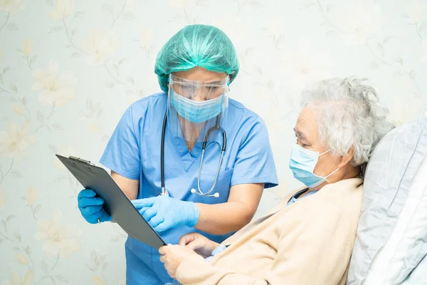 Yüz maskesi takan Asyalı bir doktor ve karantina hastanesi koğuşundaki Covid-19 Coronavirus salgınını kontrol etmek için PPE giysisi..