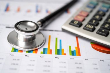 Çizelge ya da grafik kağıdı, Finansal, hesap, istatistik ve iş verileri medikal sağlık kavramı üzerine steteskop ve ABD doları banknotları.