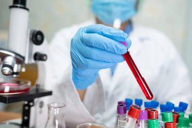 Laboratuvarda çalışan biyokimyacı ya da mikrobiyolog için mikro biyolojik tüp ile mikroskop..