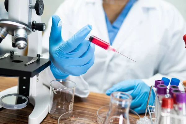 Laboratuvarda mikroskopla çalışan Asyalı biyokimyacı ya da mikrobiyolog. Coronavirus salgınını korumak için. Covid19, bakteri ve mikroplar..