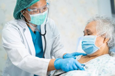 Yüz maskesi takan Asyalı bir doktor ve karantina hastanesi koğuşundaki Covid-19 Coronavirus salgınını kontrol etmek için PPE giysisi..