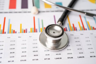 Çizelge ve grafikler üzerindeki steteskop tablo, finans, hesap, istatistik, yatırım, analitik araştırma veri ekonomisi ve işletme şirketi kavramı.