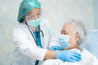 Yüz maskesi takan Asyalı bir doktor ve karantina hastanesi koğuşundaki Covid-19 Coronavirus salgınını kontrol etmek için PPE giysisi..