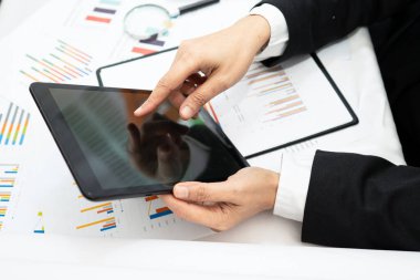 Modern ofis, finans ve iş konseptinde grafik grafik grafiği ve hesap makinesiyle çalışan ve finansal raporları analiz eden Asyalı muhasebeci.