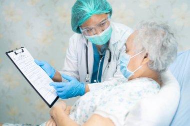 Yüz maskesi takan Asyalı bir doktor ve karantina hastanesi koğuşundaki Covid-19 Coronavirus salgınını kontrol etmek için PPE giysisi..
