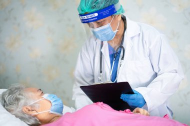 Yüz maskesi takan Asyalı bir doktor ve karantina hastanesi koğuşundaki Covid-19 Coronavirus salgınını kontrol etmek için PPE giysisi..