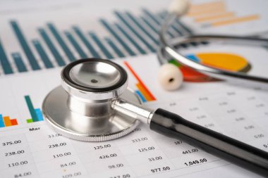 Çizelge ve grafikler üzerindeki steteskop tablo, finans, hesap, istatistik, yatırım, analitik araştırma veri ekonomisi ve işletme şirketi kavramı.