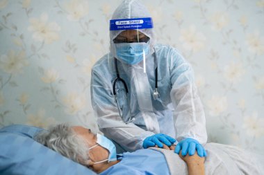 Yüz maskesi takan Asyalı bir doktor ve karantina hastanesi koğuşundaki Covid-19 Coronavirus salgınını kontrol etmek için PPE giysisi..
