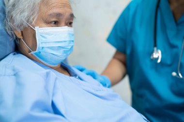 Koronavirüs Covid-19 virüsünü karantina hastanesi koğuşunda korumak için yüz maskesi takan Asyalı kadın hasta..