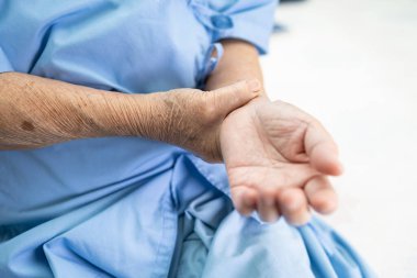 Hasta kolu ve bileği ağrıyan yaşlı Asya 'lı yaşlı kadın hemşire hastanesi koğuşunda yatarken sağlıklı, güçlü bir tıbbi konsept..
