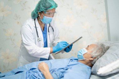 Yüz maskesi takan Asyalı bir doktor ve karantina hastanesi koğuşundaki Covid-19 Coronavirus salgınını kontrol etmek için PPE giysisi..