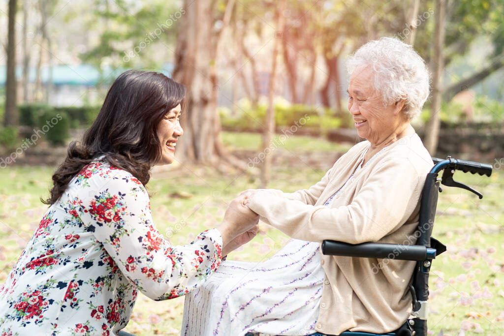 Asian senior or elderly old lady woman patient with care, help and support on wheelchair in park in holiday, healthy strong medical concept. 