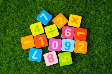 Çimen arka planda renkli matematik sayısı, eğitim eğitimi matematik öğrenimi öğretim kavramı.