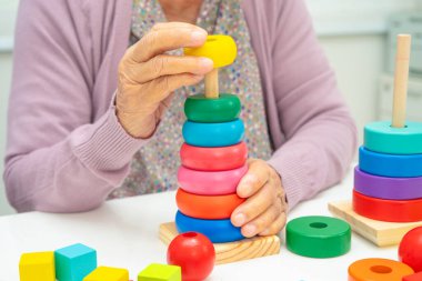 Alzheimer Hastalığı AD, bunama geçiren Asyalı yaşlı kadın hasta pratik motor beceri rehabilitasyonu öğreniyor.