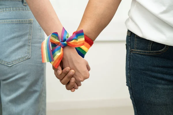 Gökkuşağı bilekliği takan Asyalı LGBT çifti..