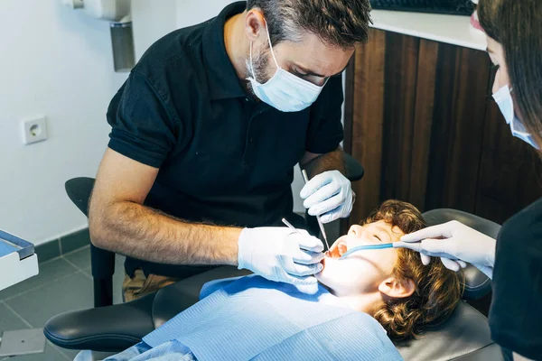 Dentist teaching little boy teeth in dental clinic