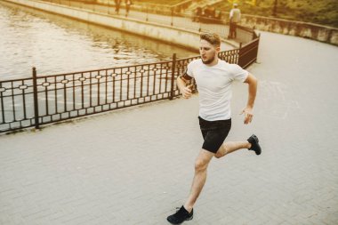 Sabah parkta koşan sağlıklı genç beyaz adam.