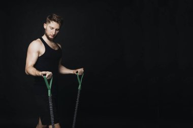 Siyah bir zemin üzerine bir stüdyoda dışarı iş yapan sportif erkek.