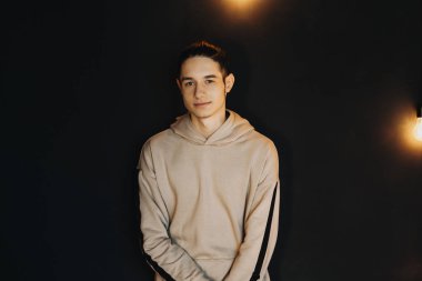 Bir sandalye üzerinde kalmak ve kameraya bakarak yakışıklı delikanlı.