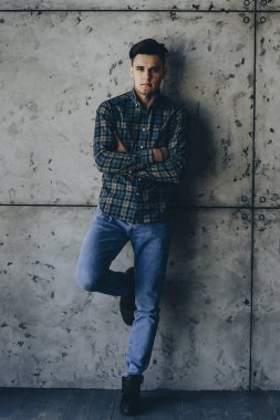 Kendine güvenen yetişkin adam gri bir arka plan ile çapraz kolları üzerinde ayakta