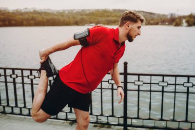 Güzel bir parkta eğitimde bir yaz günü önce streching ciddi sportif bir adamdır.