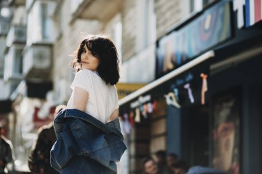 Onun tetikte ve kameraya gülümseyen kot ceketi, neşeli genç kadın giyinmiş, .