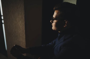 Sabah güneşin doğuşunu pencereden bakarak evde otururken yakışıklı serbest meslek.