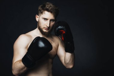 Sarışın beyaz adam elinde eldiven siyah bir zemin üzerine kalan.