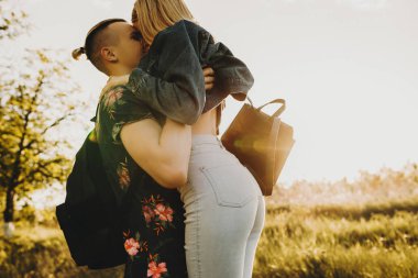 Adam onun aşk günbatımı karşı gülümseyen kucaklayan iken birbirimizi sevmek güzel genç Çift.