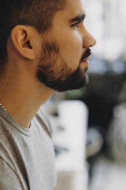 Sakallı bir adam uzakta ciddi görünümlü profil portresi yakın çekim.