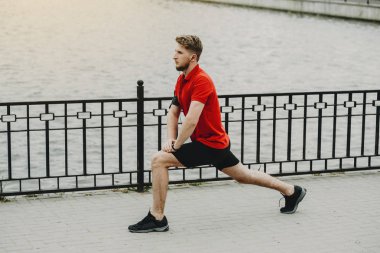 Genç sağlıklı adam sabah ayak egzersizleri yapıyor.
