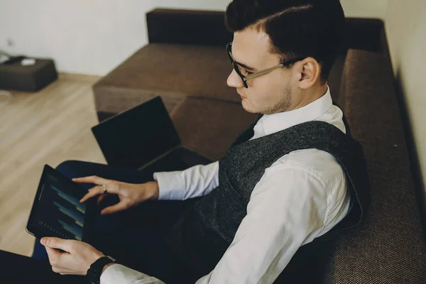 自信的年轻经理在家里工作坐在沙发上 并与活动的平板电脑操作 — 图库照片