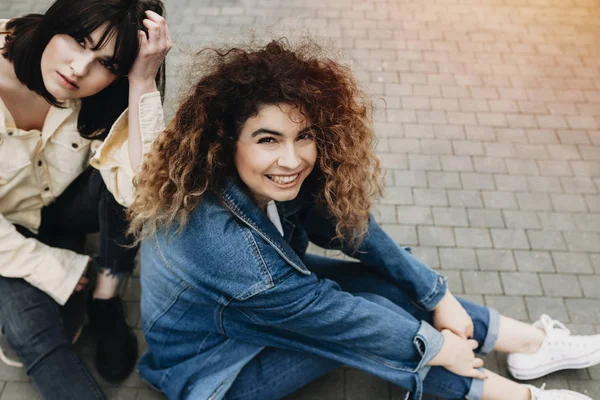 Zwei Fröhliche Mädchen Die Auf Der Straße Sitzen Und Lässiger — Stockfoto