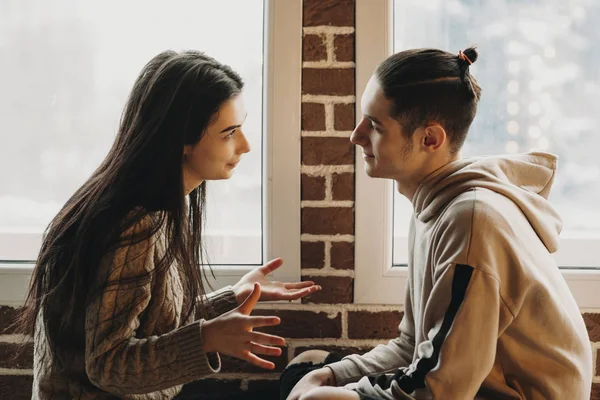 Side view of a couple that iis sitting face to face and speak.