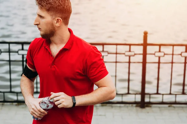 Ξανθιά Σπορ Άνθρωπος Που Ντύνεται Ένα Κόκκινο Μπλουζάκι Μένει Μπουκάλι — Φωτογραφία Αρχείου