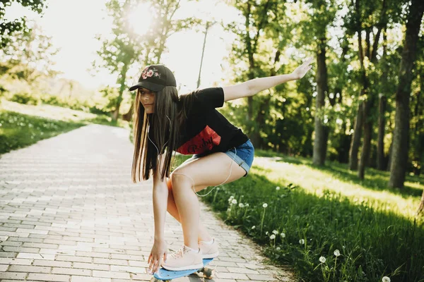 Roztomilá Mladá Dívka Skateboardingu Parku Při Poslechu Hudby Sluchátkách — Stock fotografie