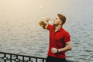 Sabah bir göl karşı parkta çalıştıran sonra içme suyu genç adam.