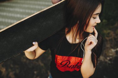 Boynunda ve dudaklarında parmak bir kaykay ile kalmak ve uzak arıyorum genç güzel kız.