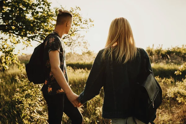 Arkadan görünüşü güzel bir beyaz çift onların el ele tutuşarak seyahat yerde arıyorsunuz.